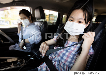 Mother and daughter fastening seat belt,woman sit in a car put on her seat belt for driving safety,child girl wearing a protective mask during the Coronavirus pandemic,spread of Covid-19,Protection Mother and daughter fastening seat belt,woman sit in a car put on her seat belt for driving safety,child girl wearing a protective mask during the Coronavirus pandemic,spread of Covid-19,Protection 68534788