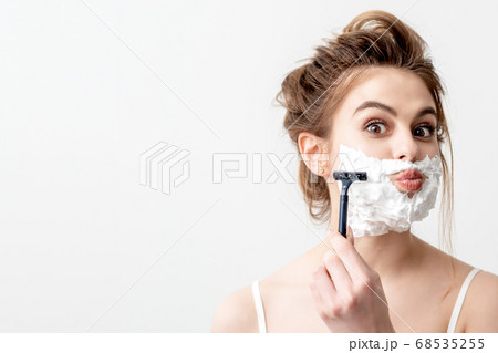 Woman shaving her face by razor 68535255