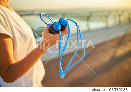 Female hand holding skipping rope for training Female hand holding skipping rope for training 68536283