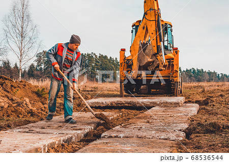 The shovel worker cleans the soil after digging 68536544