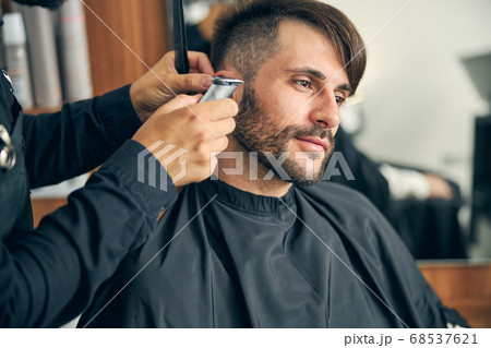 Kind young man enjoying the process of haircutting 68537621