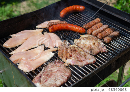 Grilling meat outdoors Grilling meat outdoors 68540068