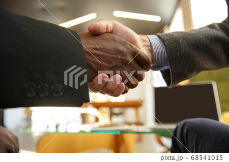 Close up of businessmen shaking hands in conference room 68541015