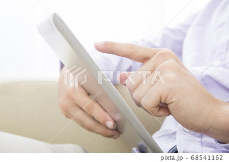 ソファに座ってタブレットPCを見る男性 ソファに座ってタブレットPCを見る男性 68541162