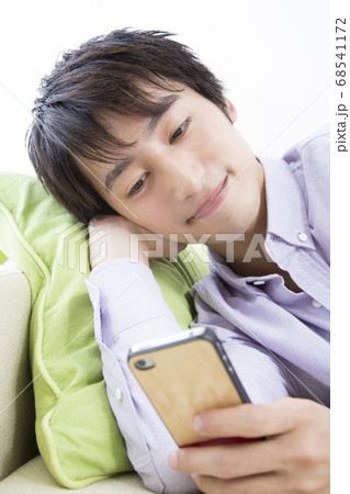 寝転んでスマホを見る男性 寝転んでスマホを見る男性 68541172