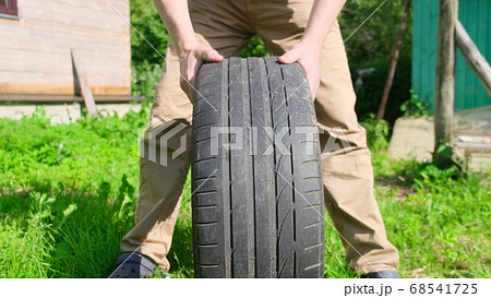 Man check tire on a car wheel outdoor summer 68541725