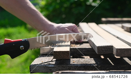 Close up shot of a hand cutting through a wooden Close up shot of a hand cutting through a wooden 68541726