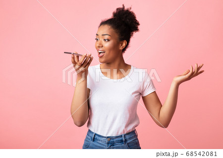 Happy afro lady using voice assistant on smart phone 68542081