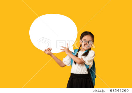 Happy Asian School Girl Holding Speech Bubble Standing In Studio Happy Asian School Girl Holding Speech Bubble Standing In Studio 68542260