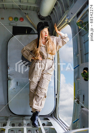 Young woman in a pilot's suit stands at the opened 68542274