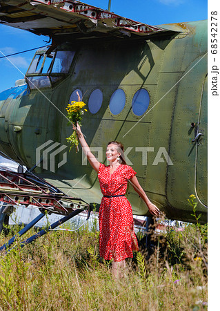 Young woman in a red pin up dress waves a bunch of 68542278