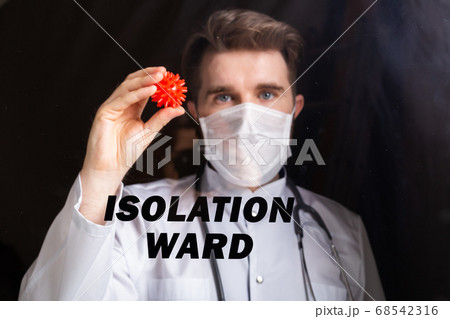 Covid-19 ward, Vaccine development and medicine concept - Doctor in flu mask holding a model of coronavirus. 68542316