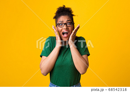 Surprised afro woman in specs screaming at studio 68542318