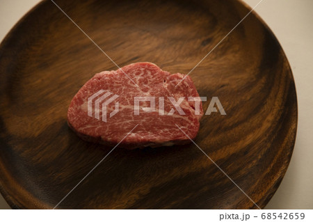 アカシアプレートにのせた生の肉厚牛フィレステーキ アカシアプレートにのせた生の肉厚牛フィレステーキ 68542659