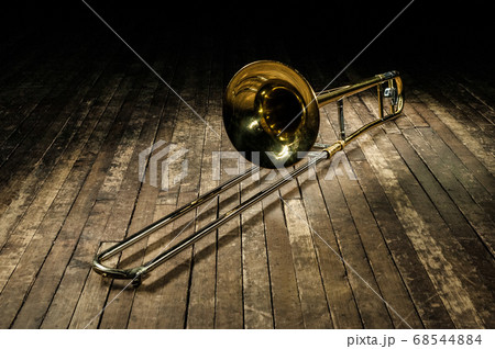 golden brass instrument trombone lies on a brown 68544884