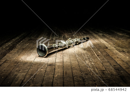a black woodwind clarinet lies on a dark brown 68544942