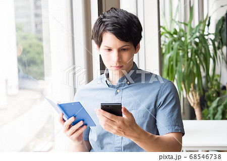 スマホと手帳を持つ若い男性 スマホと手帳を持つ若い男性 68546738