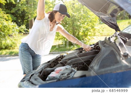 A woman in hat and denim shorts waits for 68546999
