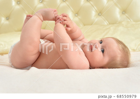 Cute little baby girl on bed smiling Cute little baby girl on bed smiling 68550979