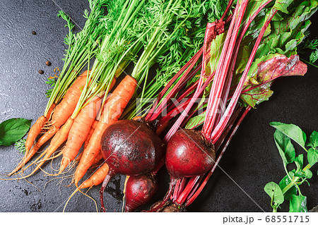 carrots with green stems and beets with leaves on a black table. copy space, close up, carrots with green stems and beets with leaves on a black table. copy space, close up, 68551715