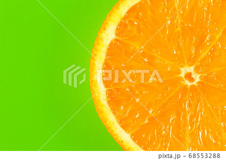orange slice on a green background macro. place for the label 68553288