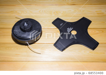 the grass trimmer. details on a wooden background.the view from the top the grass trimmer. details on a wooden background.the view from the top 68553400