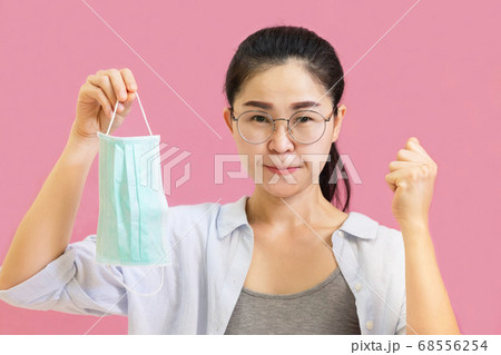 Young asian woman wore a gray undershirt, Blue shirt and protective masks against virus and air pollution,hand holding red heart, isolated on pink background,health care concept Young asian woman wore a gray undershirt, Blue shirt and protective masks against virus and air pollution,hand holding red heart, isolated on pink background,health care concept 68556254