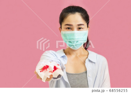 Young asian woman wore a gray undershirt, Blue shirt and protective masks against virus and air pollution,hand holding red heart, isolated on pink background,health care concept Young asian woman wore a gray undershirt, Blue shirt and protective masks against virus and air pollution,hand holding red heart, isolated on pink background,health care concept 68556255