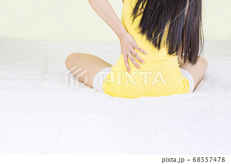 Waist pain, close up of young woman hand holding Back during sitting in the bed room, pain occur before or after sleep Waist pain, close up of young woman hand holding Back during sitting in the bed room, pain occur before or after sleep 68557478