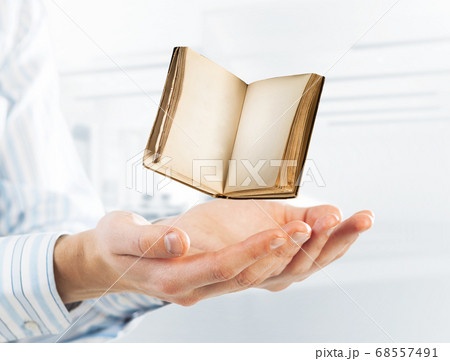 Education or writing concept with old book in male palms. Mixed media Education or writing concept with old book in male palms. Mixed media 68557491