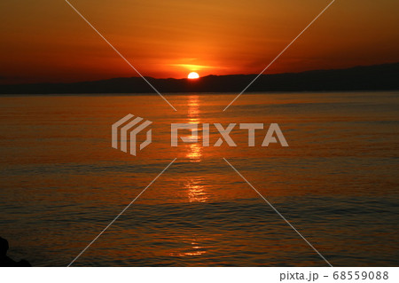 江ノ島海岸から見る伊豆半島に沈む太陽の写真素材