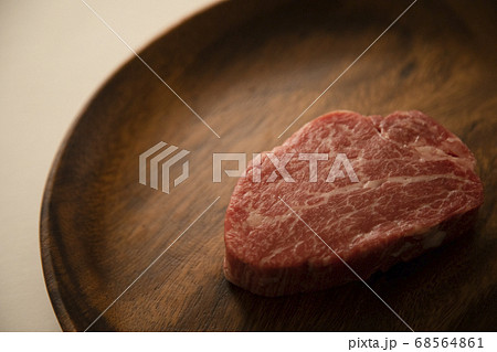 アカシアプレートにのせた生の肉厚牛フィレステーキ アカシアプレートにのせた生の肉厚牛フィレステーキ 68564861