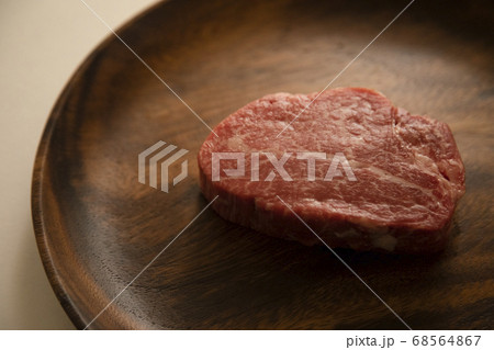 アカシアプレートに乗せた生の肉厚牛フィレステーキ アカシアプレートに乗せた生の肉厚牛フィレステーキ 68564867
