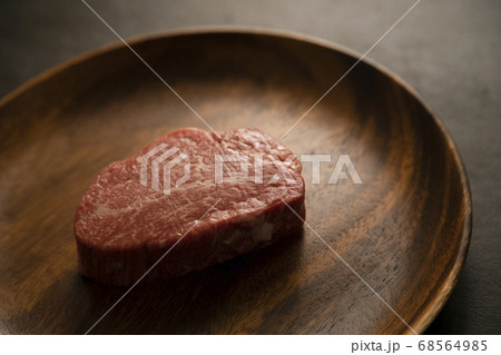 アカシアプレートに乗せた生の肉厚牛フィレステーキ 68564985