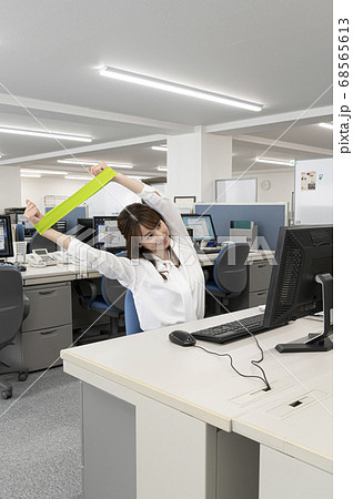 仕事の合間にストレッチをする若い女性 仕事の合間にストレッチをする若い女性 68565613