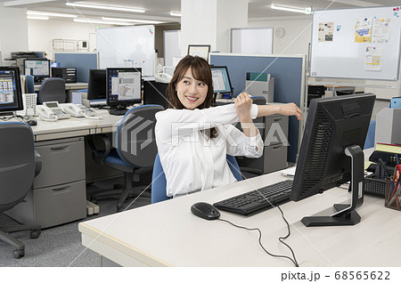 仕事の合間にストレッチをする若い女性 68565622