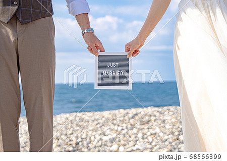 【ウェディング素材】夏の海でウェディングボードを持つ仲良し夫婦 【ウェディング素材】夏の海でウェディングボードを持つ仲良し夫婦 68566399