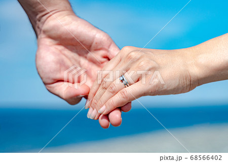 【ウェディング素材】夏の海で手を繋ぐ仲良し夫婦 68566402