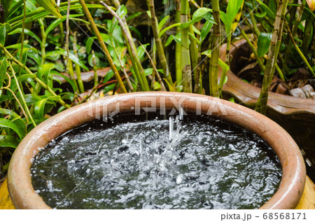 Rain Pouring Down from the Rooftop to Pottery Jar. 68568171