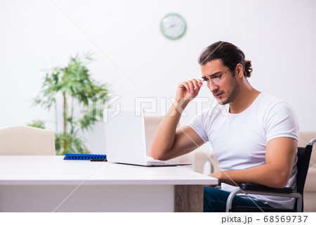 Young disabled man working from house 68569737