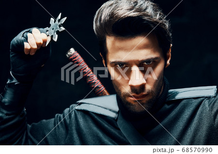 Warrior fighter with a sword and shuriken ready to stab enemy 68570990