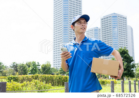 荷物を届ける宅配便の男性ドライバー 68572526
