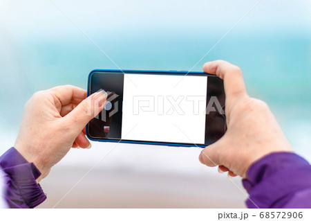 Female hand touching the screen of a smartphone 68572906