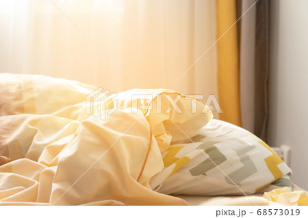 Striped pillow and duvet on the bed in the sun in the apartment Striped pillow and duvet on the bed in the sun in the apartment 68573019