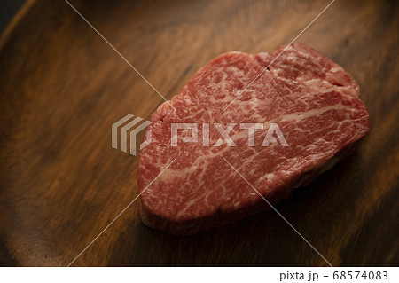 アカシアプレートに乗せた生の肉厚牛フィレステーキ アカシアプレートに乗せた生の肉厚牛フィレステーキ 68574083