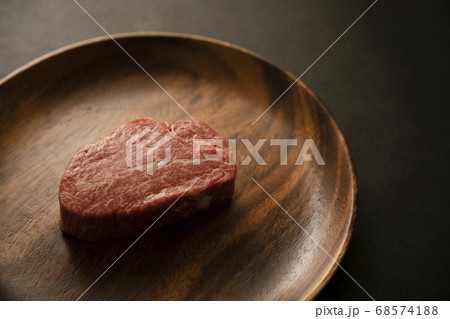 アカシアプレートに乗せた生の肉厚牛フィレステーキ アカシアプレートに乗せた生の肉厚牛フィレステーキ 68574188