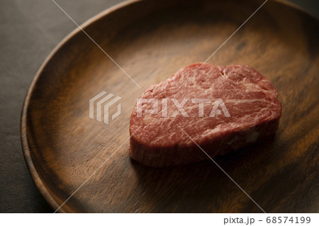 アカシアプレートに乗せた生の肉厚牛フィレステーキ 68574199