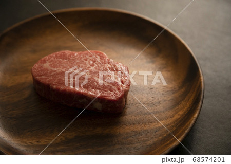 アカシアプレートに乗せた生の肉厚牛フィレステーキ アカシアプレートに乗せた生の肉厚牛フィレステーキ 68574201