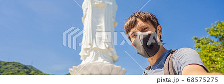 Male tourist in Da Nang, Vietnam wears a medical mask during a new wave of coronavirus in Vietnam BANNER, LONG FORMAT 68575275