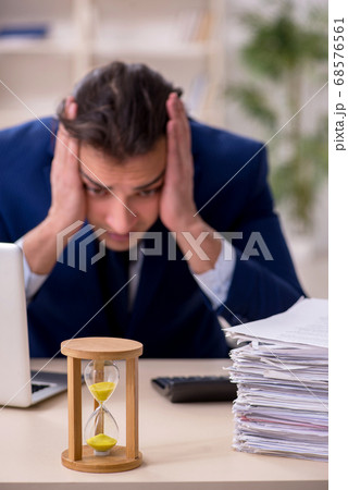 Young male employee in time management concept 68576561